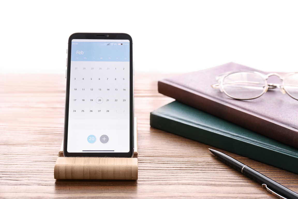 Smartphone with Calendar App on Wooden Table